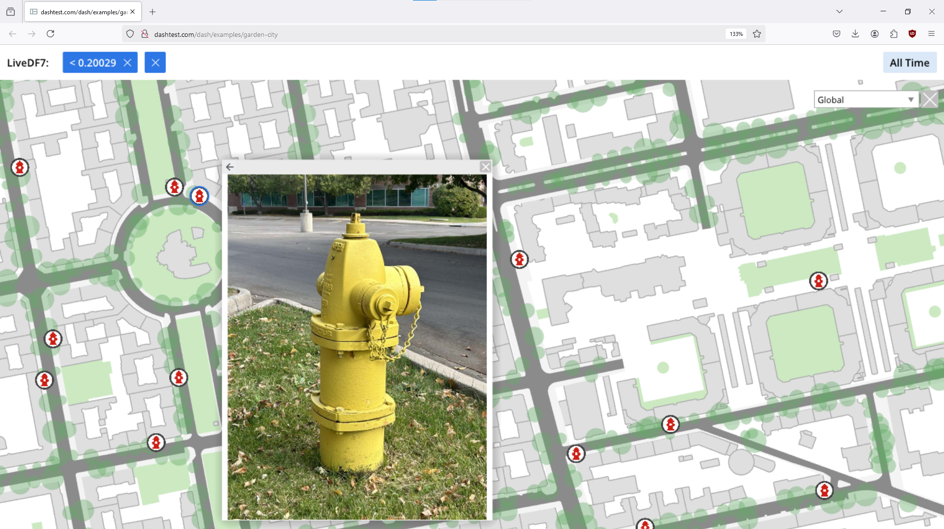 A yellow fire hydrant is located on a street corner.